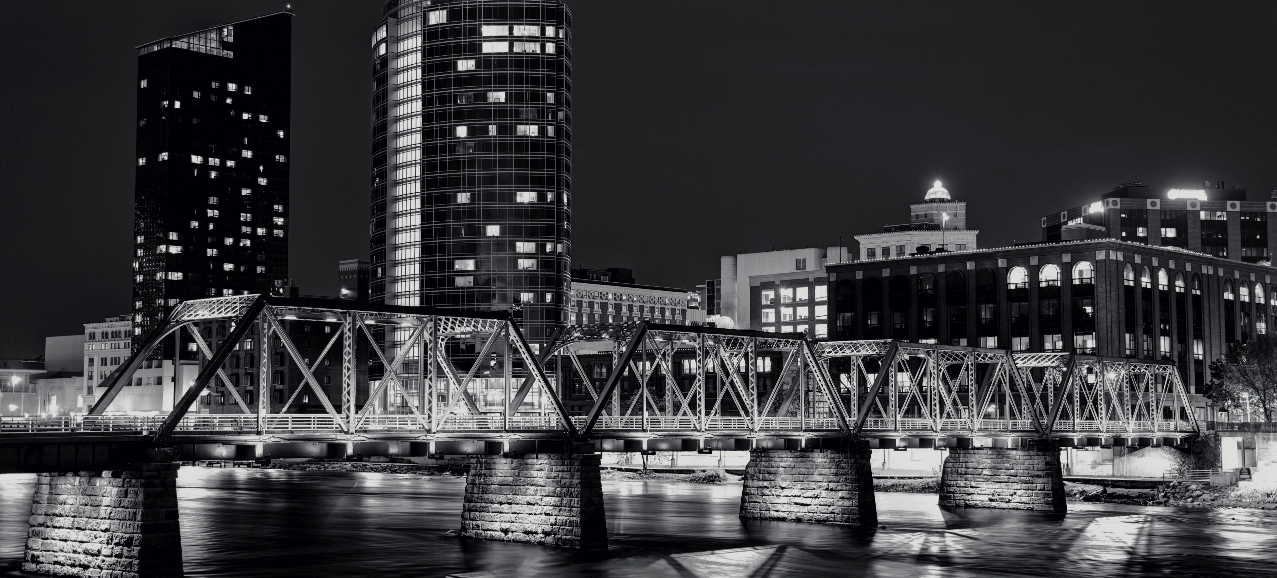 Grand Rapids skyline at night with illuminated bridge over the Grand River